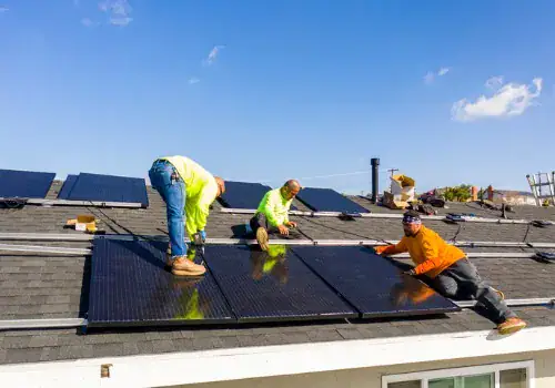 team of workers installing solar panels on residential rooftop in picture id1303757029.jpg