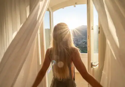 woman opening curtains in room at sunrise.jpg s1024x1024wisk20c45tppodudu6e2 z4qke3cmiqk 0g5iodns adrokqlk.jpg