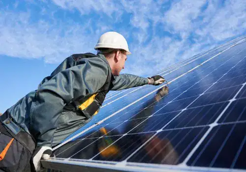 workman standing on the ground trying to fasten solar batteries picture id1222813507.jpg